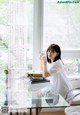 A woman sitting at a table with a cup of coffee.