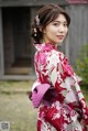 A woman in a red and white kimono posing for a picture.