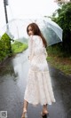 A woman walking in the rain holding an umbrella.