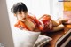 A woman in a red kimono laying on a bed.