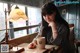 A woman sitting at a table with a cup of coffee.