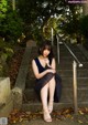 A woman sitting on the steps of a stone building.