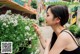 A woman in a black tank top smelling a bunch of flowers.