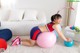 A woman is sitting on an exercise ball in a living room.