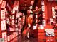 A woman in an orange dress standing in front of a store.